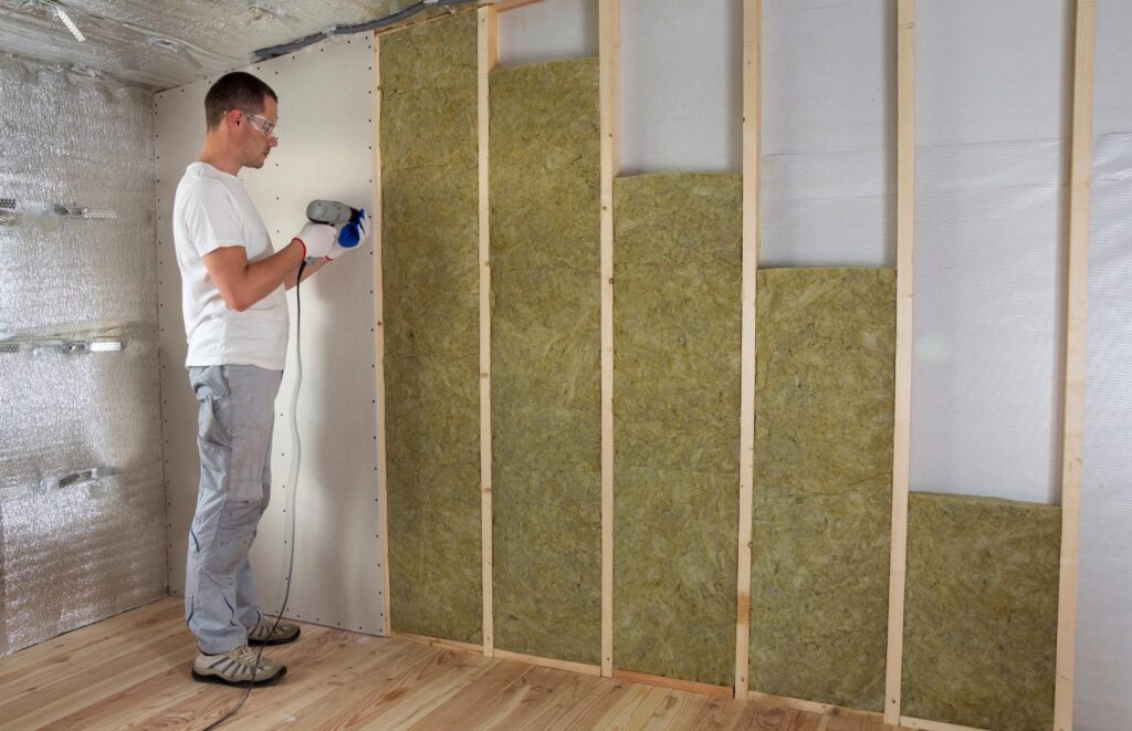 Man installing wall insulation material.