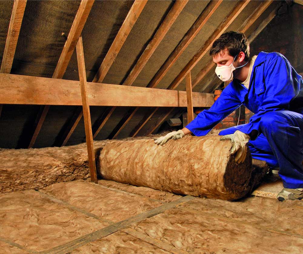 Person installing insulation in attic